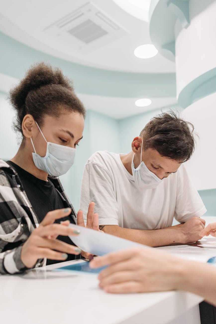 woman with face mask reading document in clinic