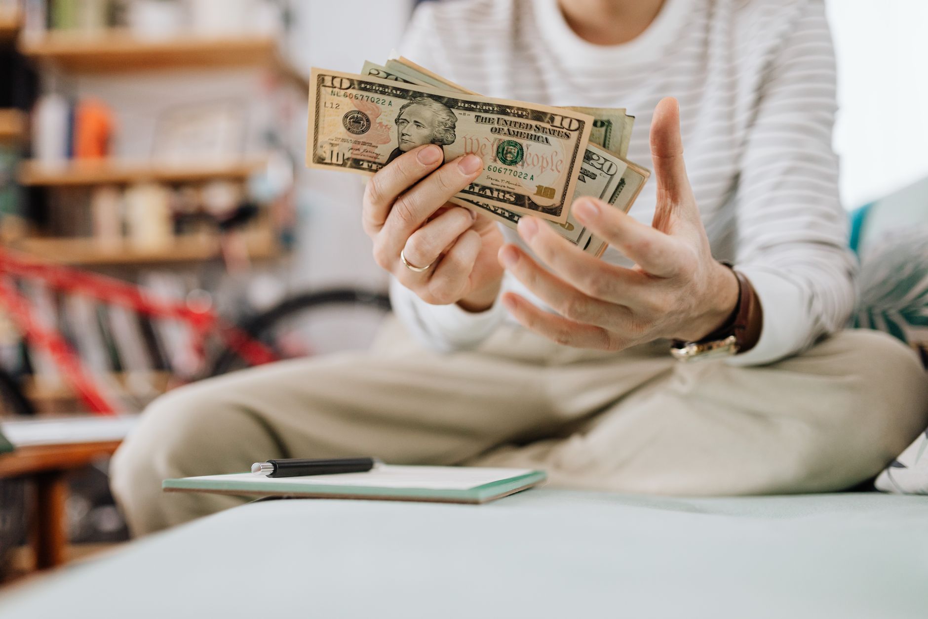 man sitting on sofa and holding money
