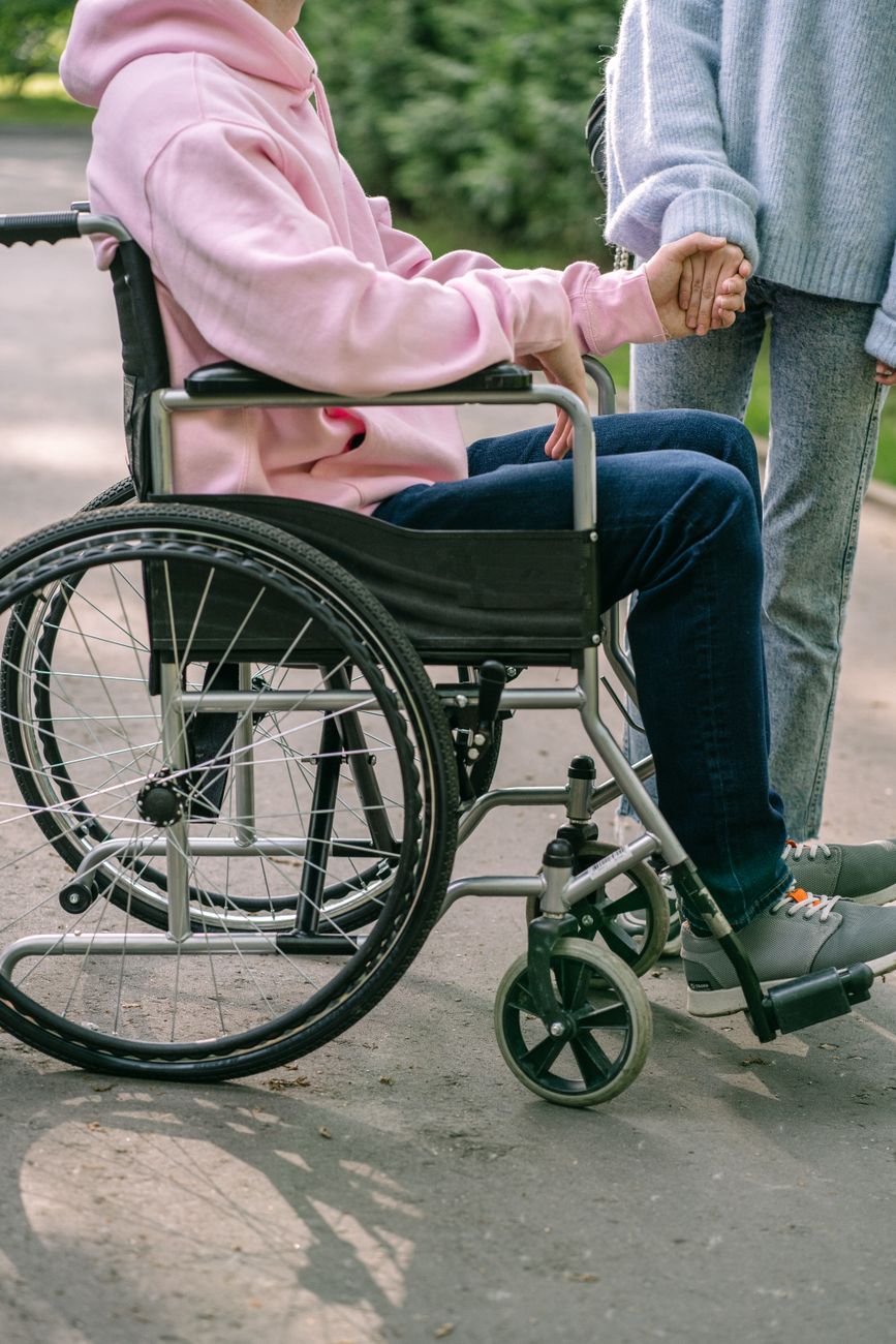 a person in pink hoodie sitting on the wheelchair